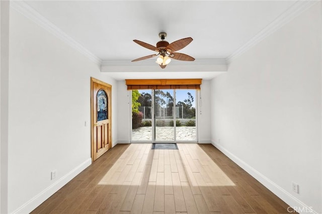 unfurnished room featuring crown molding, baseboards, ceiling fan, and wood finished floors