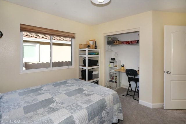 carpeted bedroom featuring a closet and baseboards