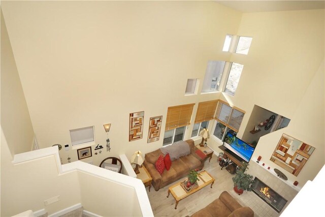 living room with a tile fireplace and a high ceiling