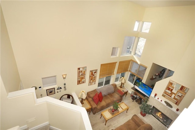 living room featuring a high ceiling and a tiled fireplace