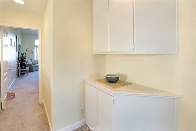 hall with light carpet and baseboards