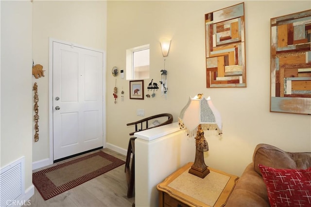 entryway featuring wood finished floors, visible vents, and baseboards