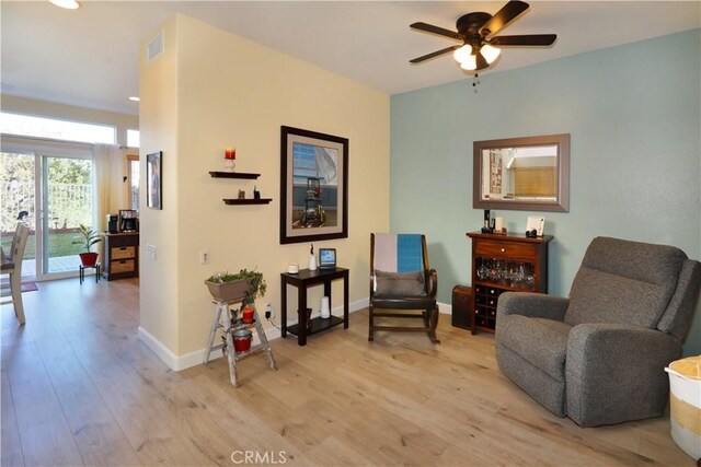 living area with ceiling fan and light wood-type flooring