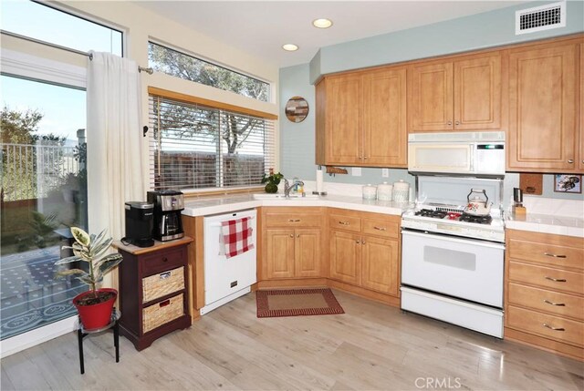 kitchen featuring sink, white appliances, and light hardwood / wood-style floors