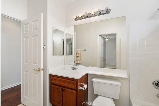 bathroom featuring wood finished floors, vanity, toilet, and shower / bathtub combination