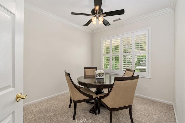 carpeted dining area featuring visible vents, ornamental molding, and baseboards