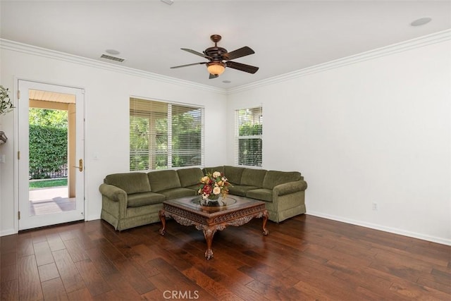 living room featuring dark wood-style flooring, visible vents, and crown molding