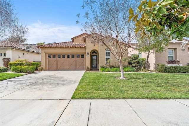 mediterranean / spanish-style home with a garage, concrete driveway, a front lawn, and stucco siding