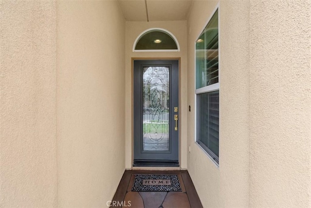 view of exterior entry featuring stucco siding