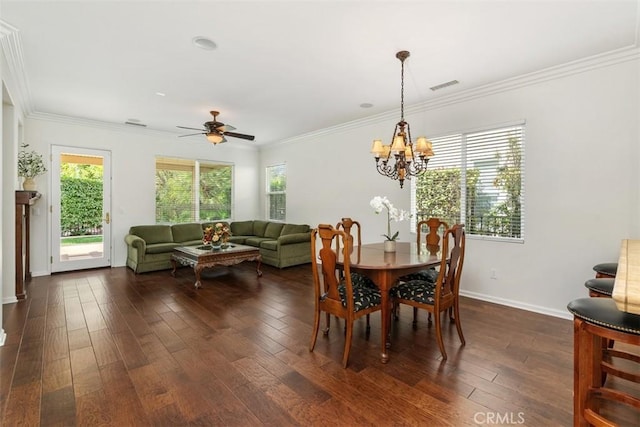 dining room featuring baseboards, visible vents, ornamental molding, dark wood-type flooring, and ceiling fan with notable chandelier