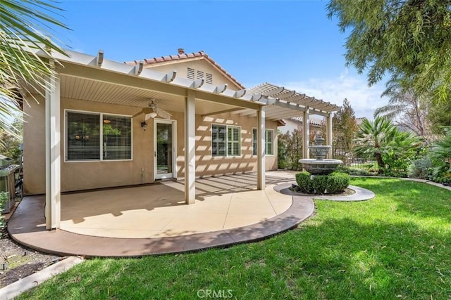 back of house featuring a patio, a ceiling fan, a lawn, stucco siding, and a pergola