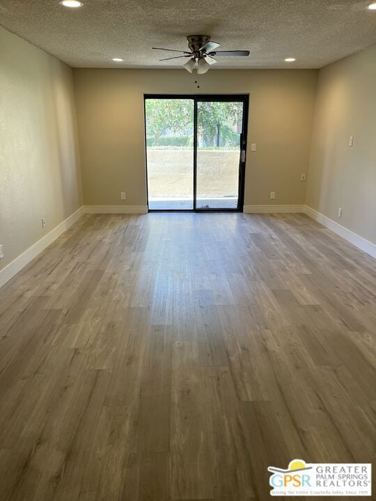 spare room featuring hardwood / wood-style flooring, a textured ceiling, and ceiling fan