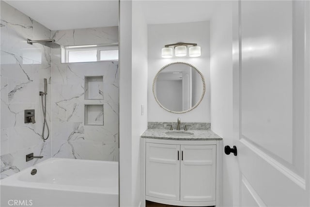 bathroom with tiled shower / bath and vanity