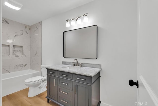 full bathroom with tiled shower / bath, wood-type flooring, toilet, and vanity