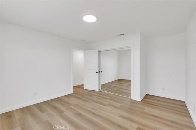 unfurnished bedroom featuring light hardwood / wood-style floors and a closet