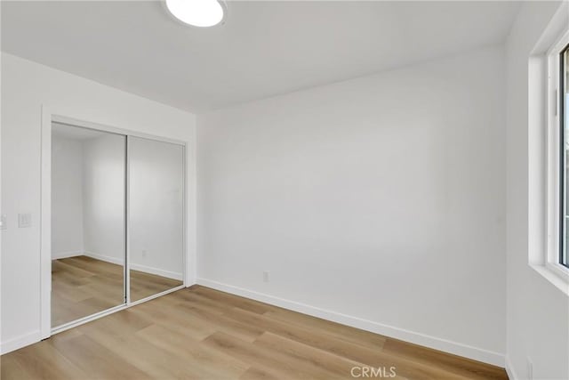 unfurnished bedroom featuring hardwood / wood-style floors and a closet