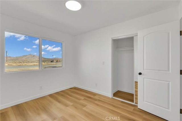 unfurnished bedroom featuring a closet and light hardwood / wood-style flooring