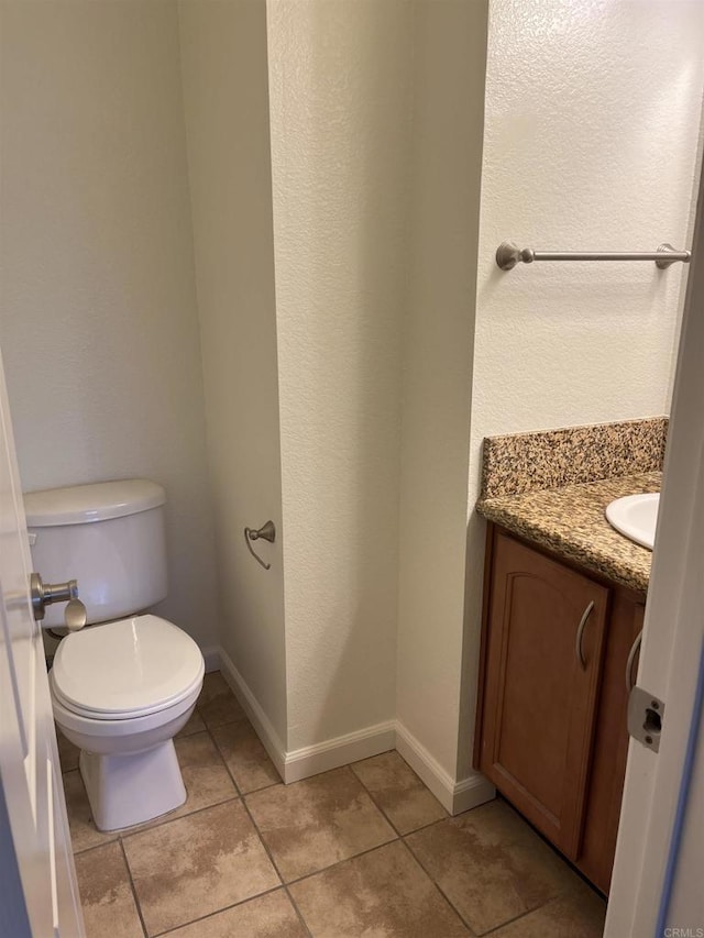 bathroom featuring tile patterned floors, vanity, and toilet