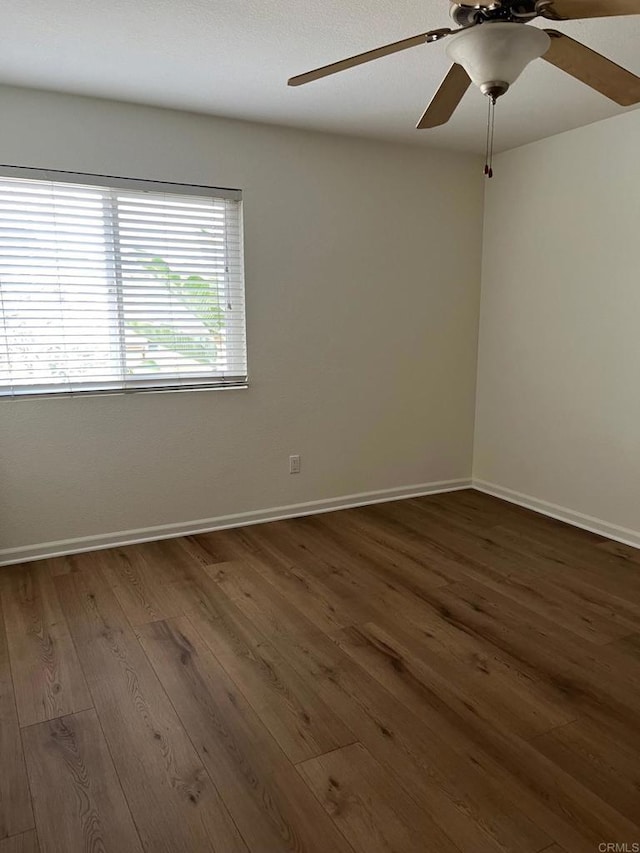 empty room with dark wood-type flooring and ceiling fan