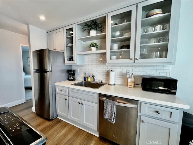 kitchen with sink, tasteful backsplash, black appliances, dark hardwood / wood-style flooring, and white cabinets