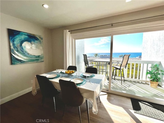 dining area featuring a water view and hardwood / wood-style floors