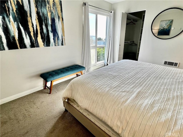 bedroom featuring a spacious closet, a closet, and carpet