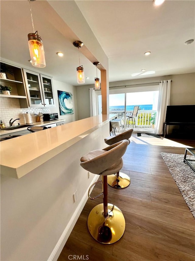 bar featuring pendant lighting, backsplash, and dark hardwood / wood-style floors