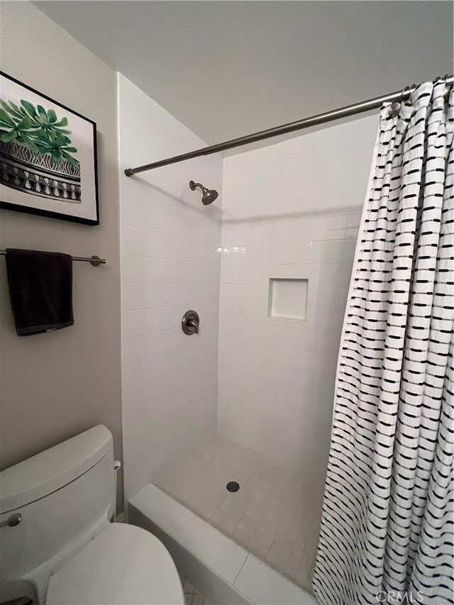 bathroom featuring toilet and a shower with shower curtain