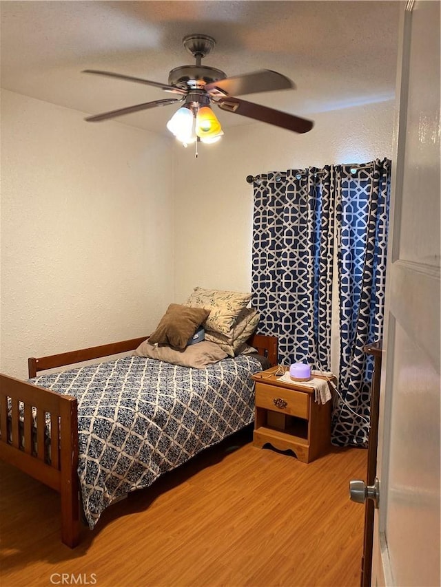 bedroom featuring wood-type flooring and ceiling fan