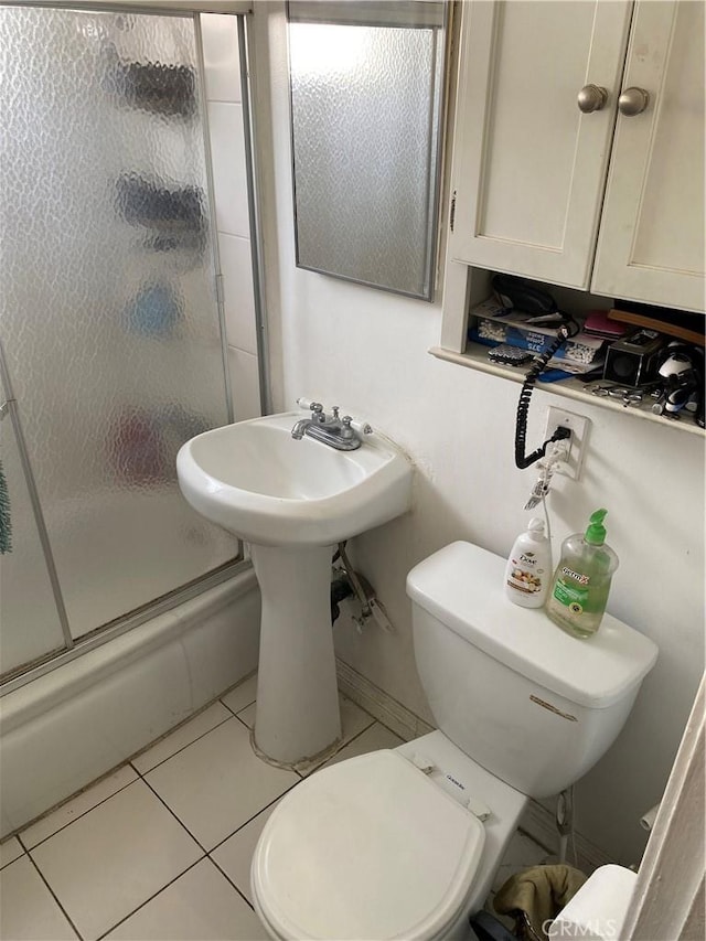 bathroom with shower / bath combination with glass door, tile patterned floors, and toilet