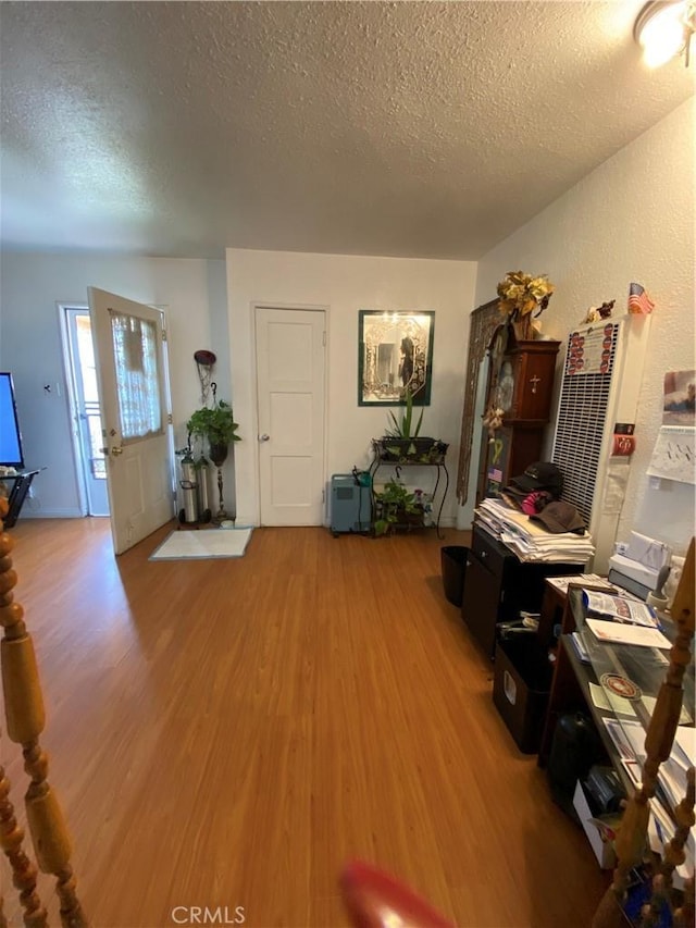 interior space featuring hardwood / wood-style flooring and a textured ceiling