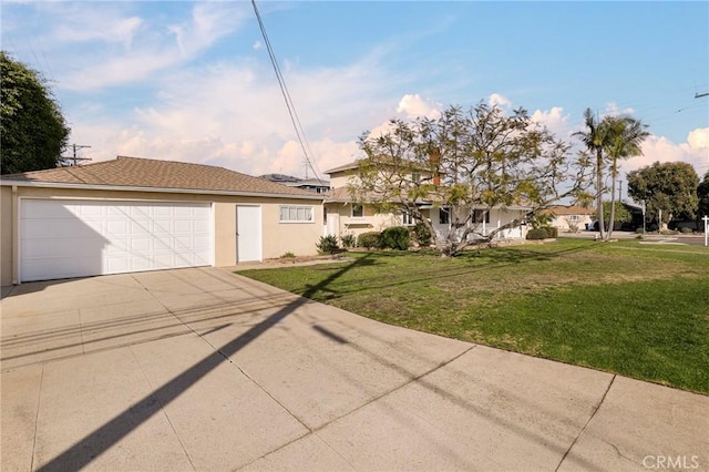 view of front of home with a garage, driveway, a front lawn, and stucco siding