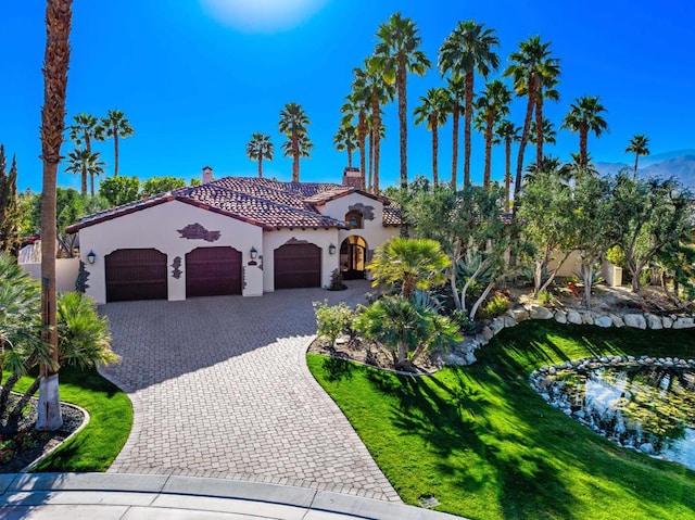 mediterranean / spanish-style house with a garage and a front yard