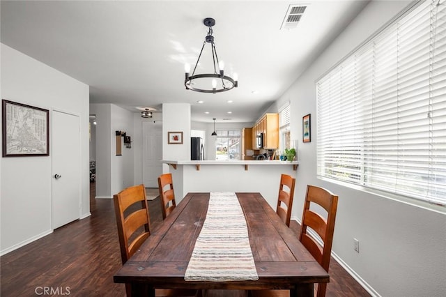 dining space with a chandelier and dark hardwood / wood-style flooring