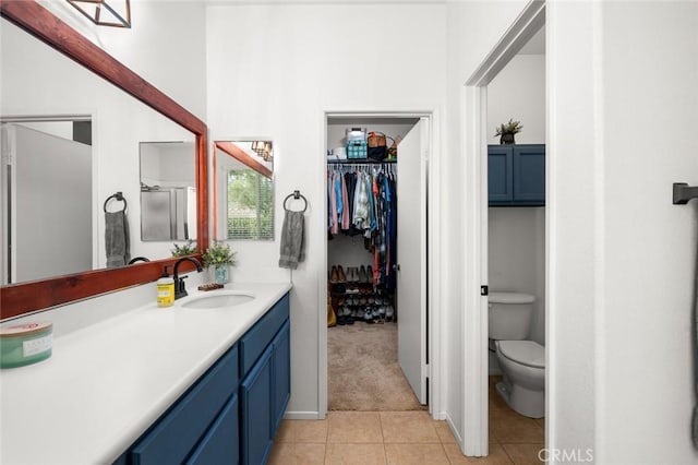 bathroom with tile patterned flooring, vanity, and toilet