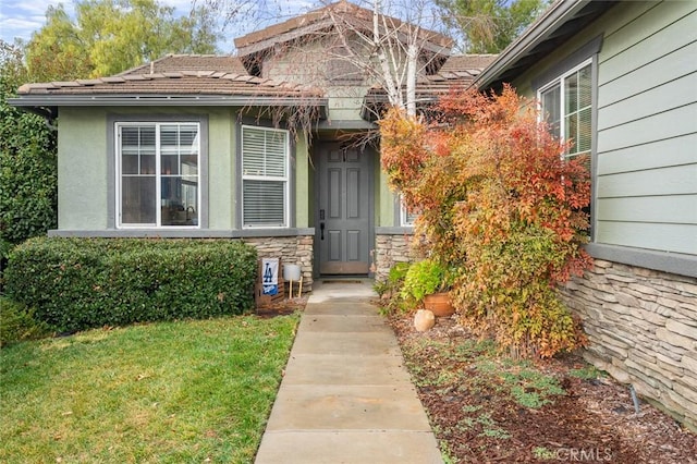 doorway to property with a lawn