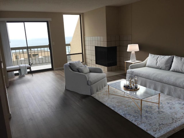 living room featuring a water view, a tile fireplace, and hardwood / wood-style flooring