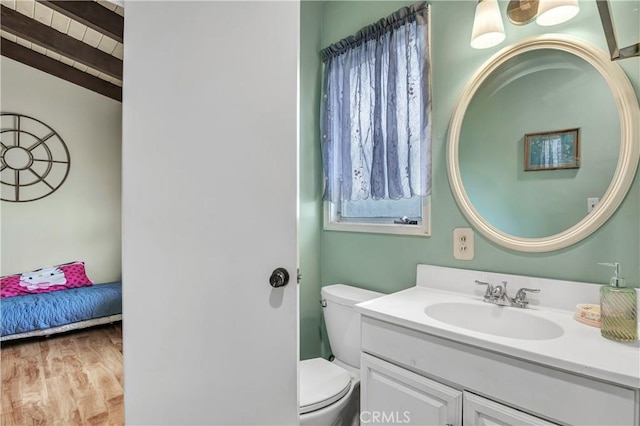 bathroom featuring vanity, hardwood / wood-style floors, and toilet