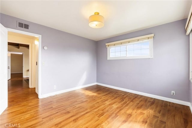 empty room with hardwood / wood-style flooring