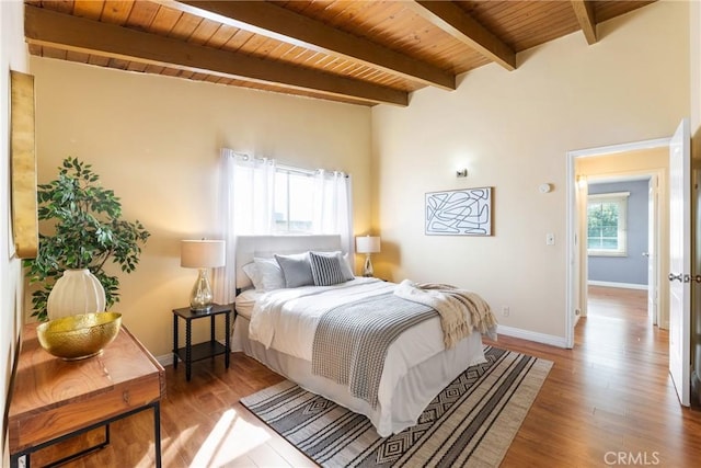 bedroom featuring beam ceiling, wood-type flooring, and wood ceiling