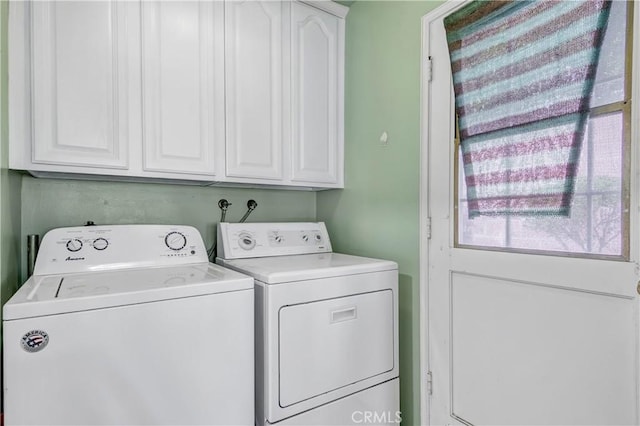 washroom with cabinets and washer and dryer