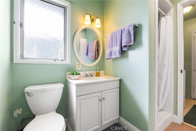 bathroom featuring toilet, vanity, and a shower with shower curtain