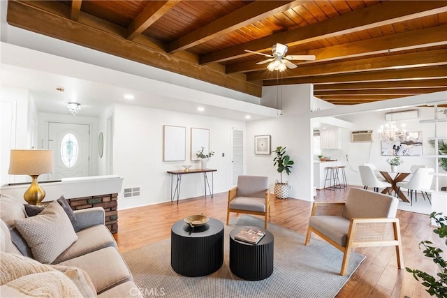 living room featuring an AC wall unit, wooden ceiling, light wood-type flooring, beamed ceiling, and ceiling fan with notable chandelier