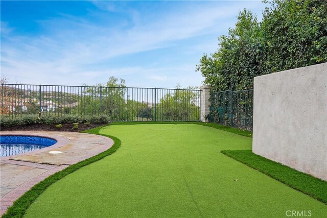 view of yard featuring a fenced in pool and fence