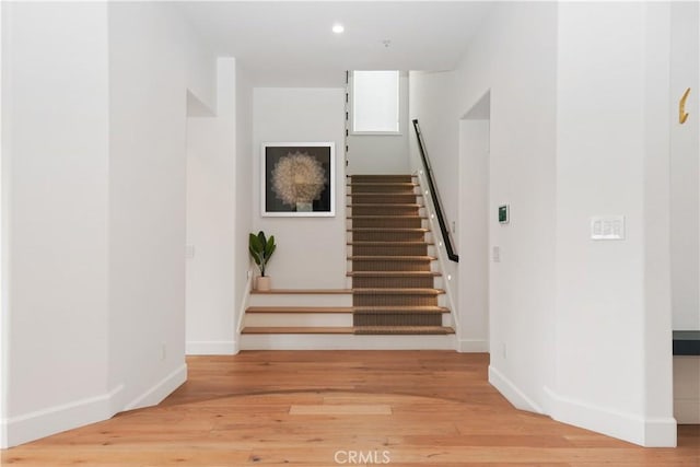 staircase with recessed lighting, wood finished floors, and baseboards