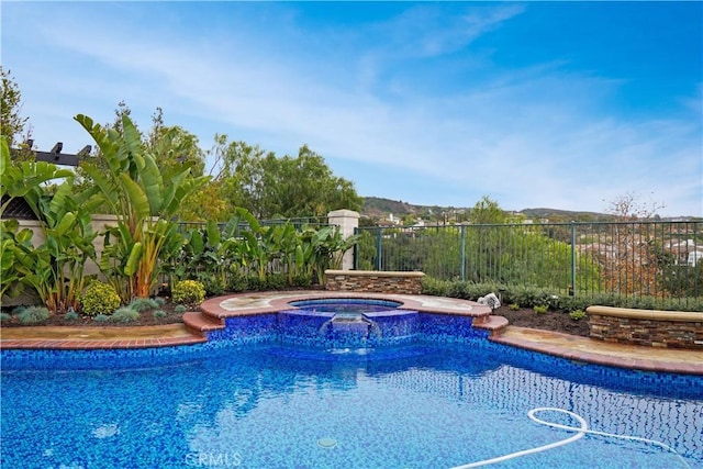 view of swimming pool with an in ground hot tub