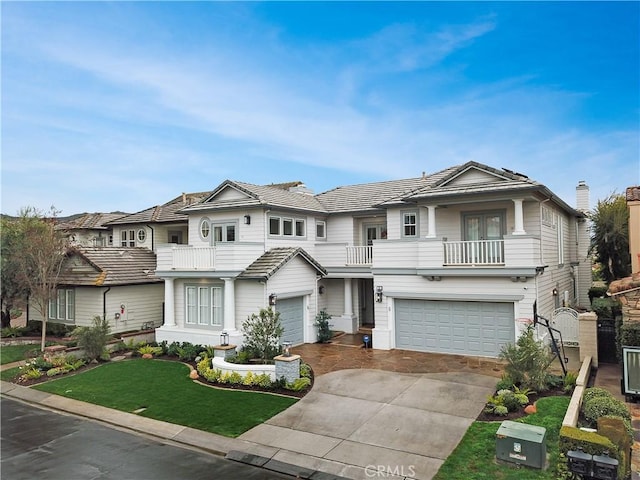 view of front of home featuring a garage, a balcony, and a front lawn