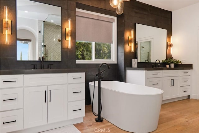 bathroom with tasteful backsplash, wood-type flooring, shower with separate bathtub, and vanity