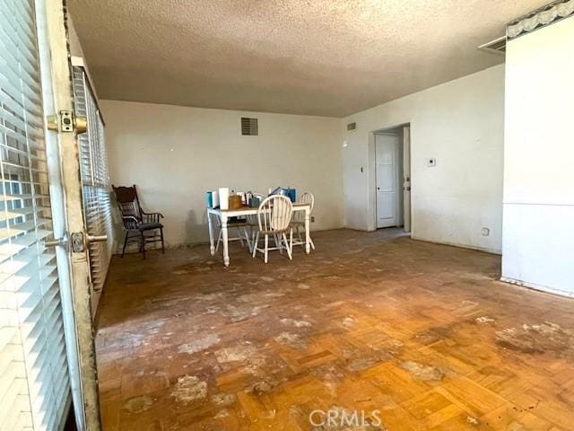 unfurnished dining area with a textured ceiling