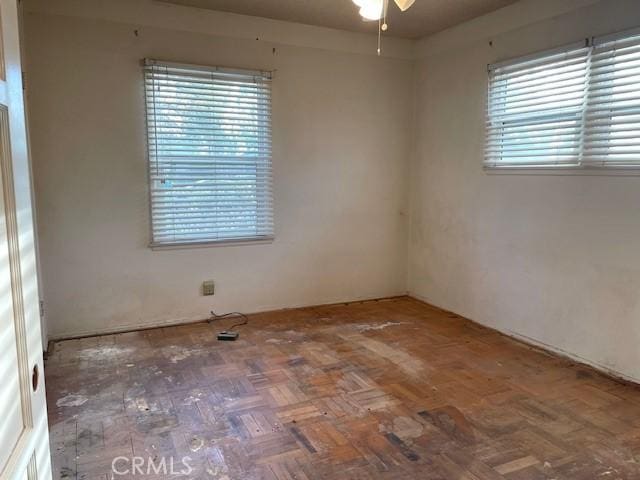 unfurnished room with parquet floors and ceiling fan